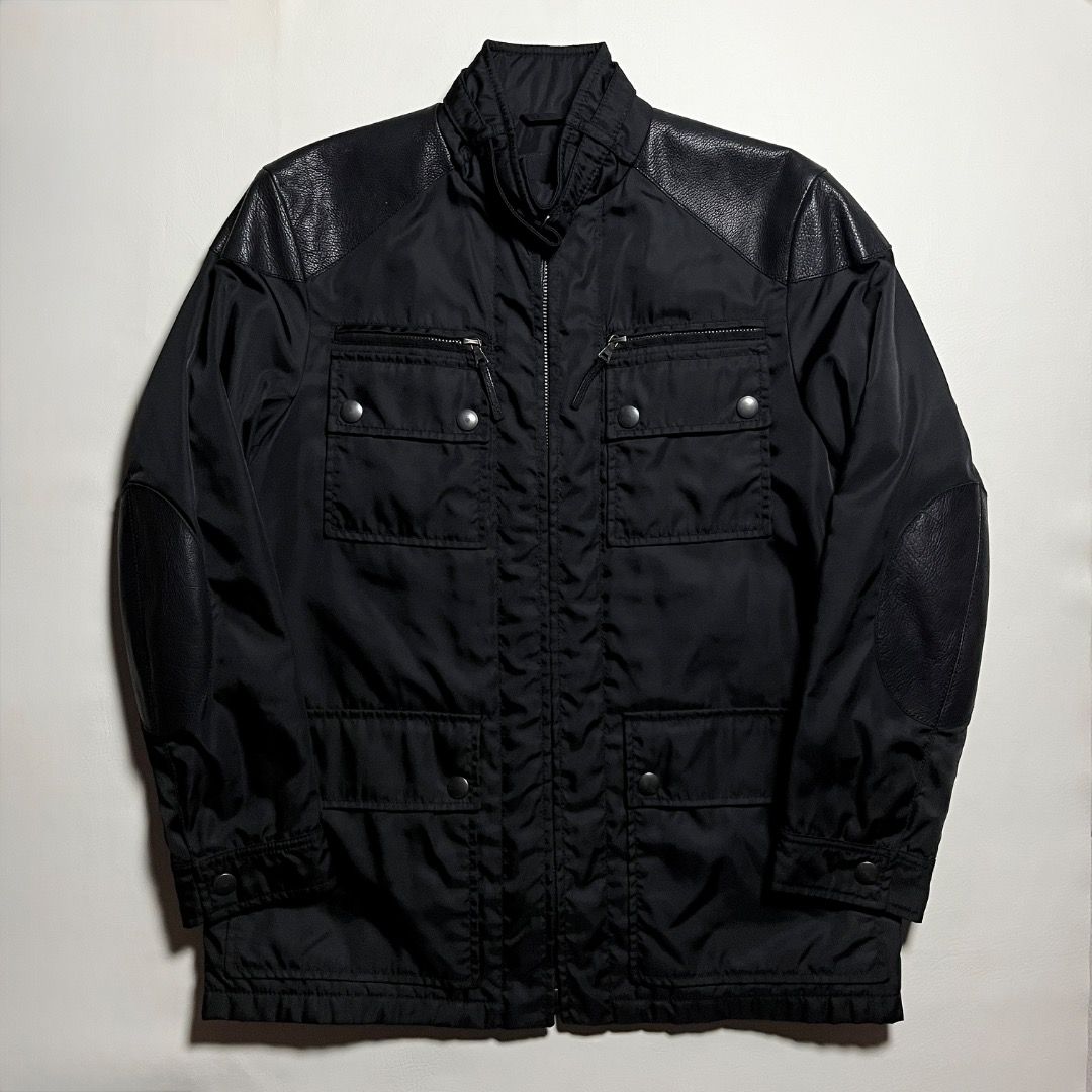 Authentic Prada Black Nylon Utility Jacket with Leather Accents (Category: Luxury Apparel) located in Caloocan City. Submitted by achilles_grails (Listing ID 1471039912, Image 1). Description: - Authentic Prada nylon utility jacket in classic black - Full front zip closure with high funnel neck and snap buttons - Multiple practical cargo pockets and zippered compartments - Stylish textured leather panels on shoulders and elbow patches - Premium b