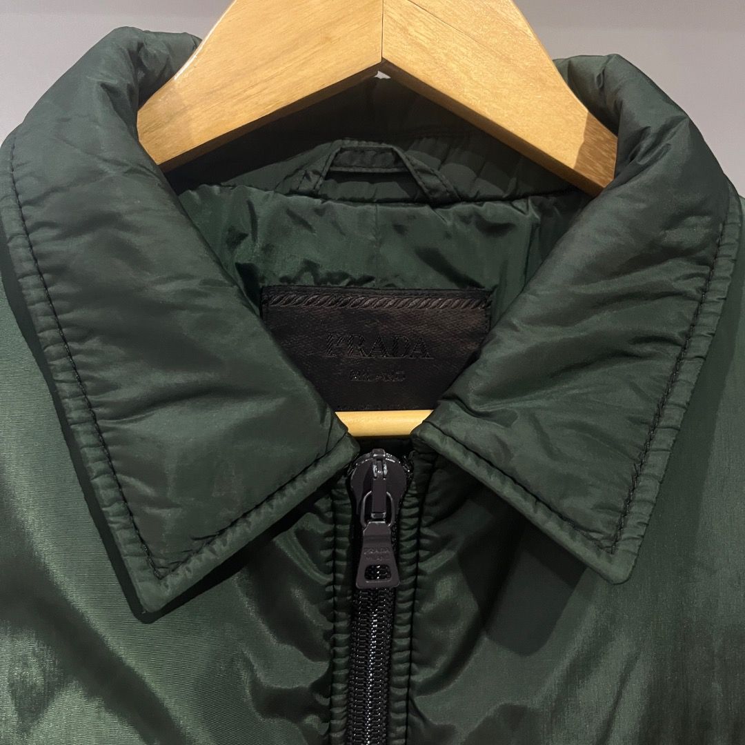 Authentic Prada Dark Green Insulated Harrington Jacket (Category: Coats, Jackets and Outerwear) located in Caloocan City. Submitted by achilles_grails (Listing ID 1471028356, Image 2). Description: - Color: Dark green - Size: XL - Style: Zip-up jacket with classic collar and clean chest stitching - Warmth: Quilted puffer lining for extra insulation - Features: Two front slanted pockets, ribbed cuffs, and hem to block the wind - Condition: Smooth 
