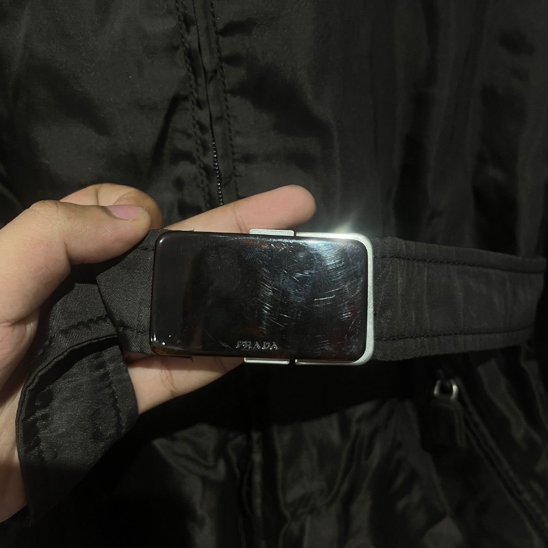 Authentic Prada Nylon Belted Trench Coat (Category: Coats, Jackets and Outerwear) located in Caloocan City. Submitted by achilles_grails (Listing ID 1471028182, Image 2). Description: - Brand: Prada - Color: Classic Black - Material: Lightweight nylon - Features: Full front zip closure, pointed collar, and long sleeves - Included: Matching fabric belt with silver-tone Prada-engraved buckle - Style: Timeless layering piece.