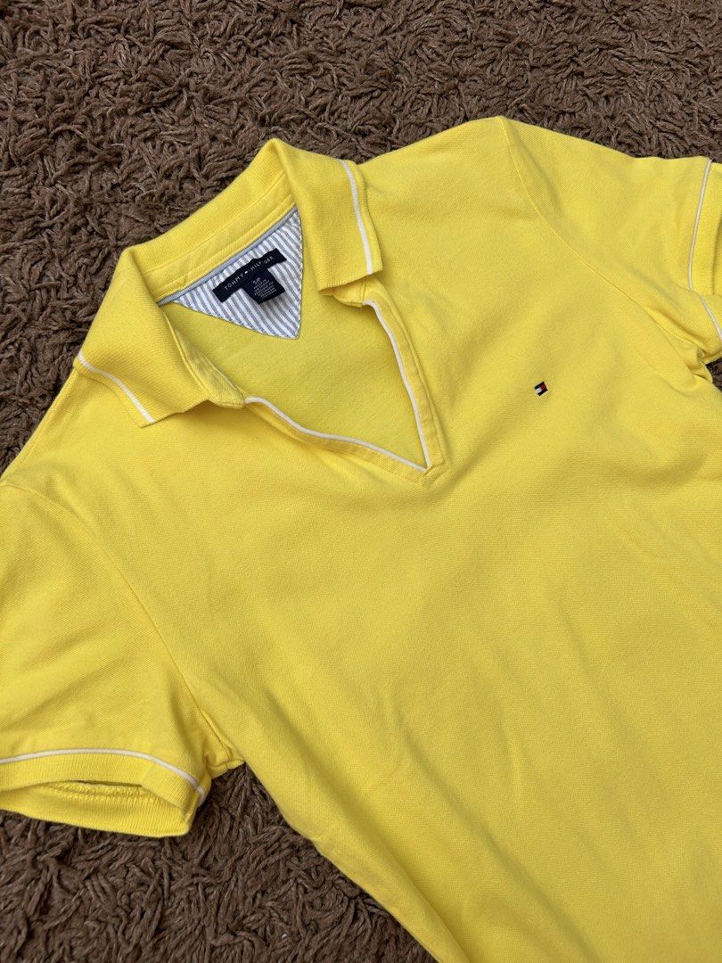 Authentic TH Polo Shirt Women's (Category: Shirts) located in Paranaque City. Submitted by madenise_declutter (Listing ID 1470976780, Image 1). Description: - Brand: Tommy Hilfiger - Size: S - Color: Bright yellow with white trim and blue/white striped inner collar - Style: Short sleeve, collared V-neck - Details: Small embroidered signature flag logo on left chest - Origin: Made in Vietnam with inner care tags intact - Condition: Clean fabric, p