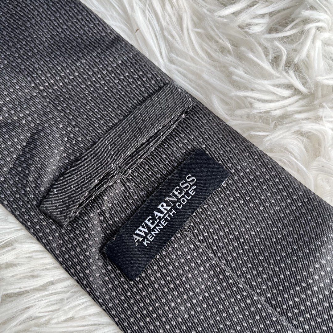Awearness Kenneth Cole Men's Black Micro Dot Silk Necktie (Category: Ties) located in Cuyapo. Submitted by Ashtyn.Pre.Loved (Listing ID 1471019422, Image 2). Description: - Brand: Awearness Kenneth Cole - Color: Classic black with tiny white micro dots - Width: Standard 3.25 inches across the blade tip - Versatility: Easy to match with various dress shirts and suits - Occasion: Ideal for work, weddings, and formal events - Condition: Clean back l