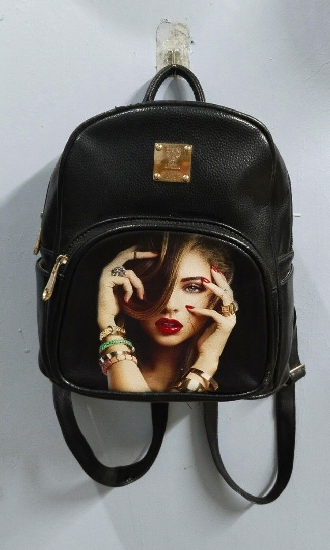 Back pack medium (Category: Backpacks) located in Trece Martires City. Submitted by vherma (Listing ID 1470944293, Image 2). Description: black faux-leather (PU) mini backpack featuring a graphic print of a woman on the front pocket and gold-tone hardware..