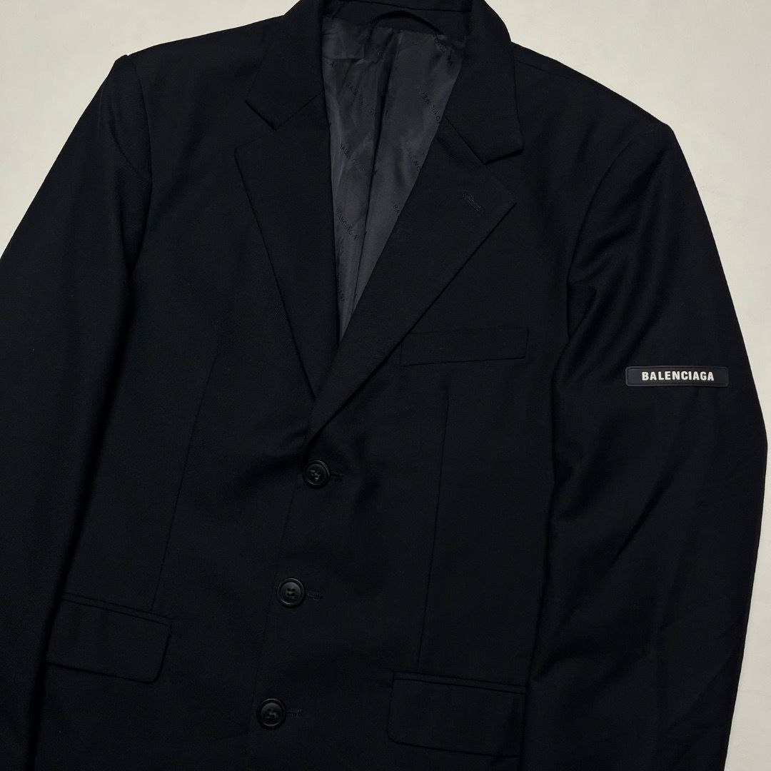 Balenciaga Black Wool Blazer with Sleeve Patch (Category: Coats, Jackets and Outerwear) located in Caloocan City. Submitted by achilles_grails (Listing ID 1471078391, Image 2). Description: - Brand: Balenciaga - Color: Black - Material: Premium wool with black jacquard logo lining - Fit: Tailored fit with structured shoulders - Closure: Three-button front with branded hardware - Details: Rubber Balenciaga logo patch on left sleeve and interior po
