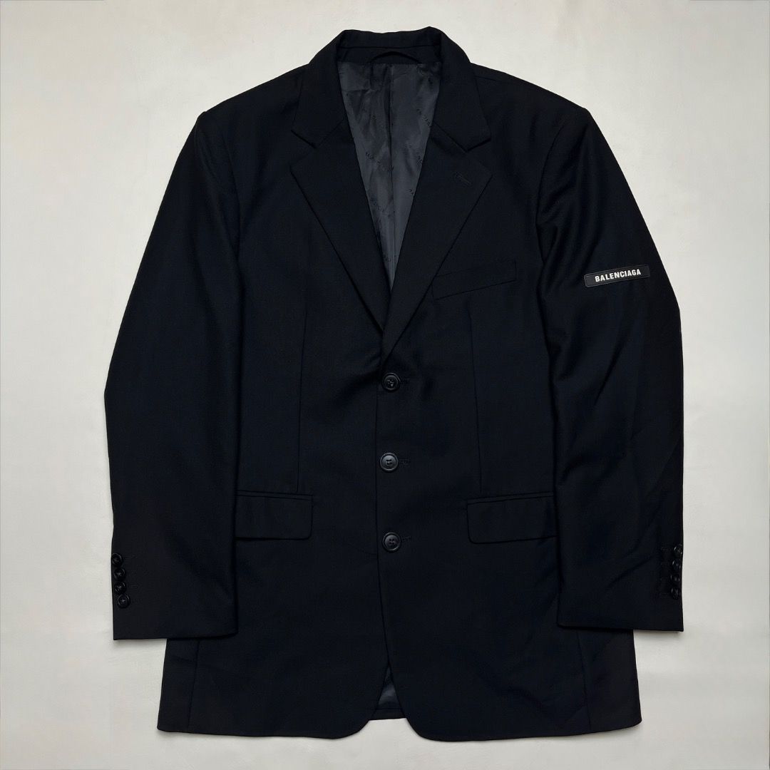 Balenciaga Black Wool Blazer with Sleeve Patch (Category: Coats, Jackets and Outerwear) located in Caloocan City. Submitted by achilles_grails (Listing ID 1471078391, Image 1). Description: - Brand: Balenciaga - Color: Black - Material: Premium wool with black jacquard logo lining - Fit: Tailored fit with structured shoulders - Closure: Three-button front with branded hardware - Details: Rubber Balenciaga logo patch on left sleeve and interior po