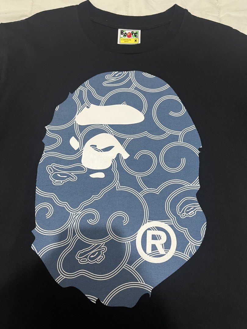 BAPE Blue Wave Ape Head (Category: Tshirts & Polo Shirts ) located in Manila. Submitted by westbridge007 (Listing ID 1471071548, Image 2). Description: BAPE Blue Wave Ape Head Graphic T-Shirt – Black Price: ₱3,000 Size: Medium (M, tag shown) Condition: Pre-owned / Very good condition Black BAPE graphic tee featuring a large blue pattern ape head design with white detailing. * Unique blue graphic * Black base color * Short sleeves * Front and back