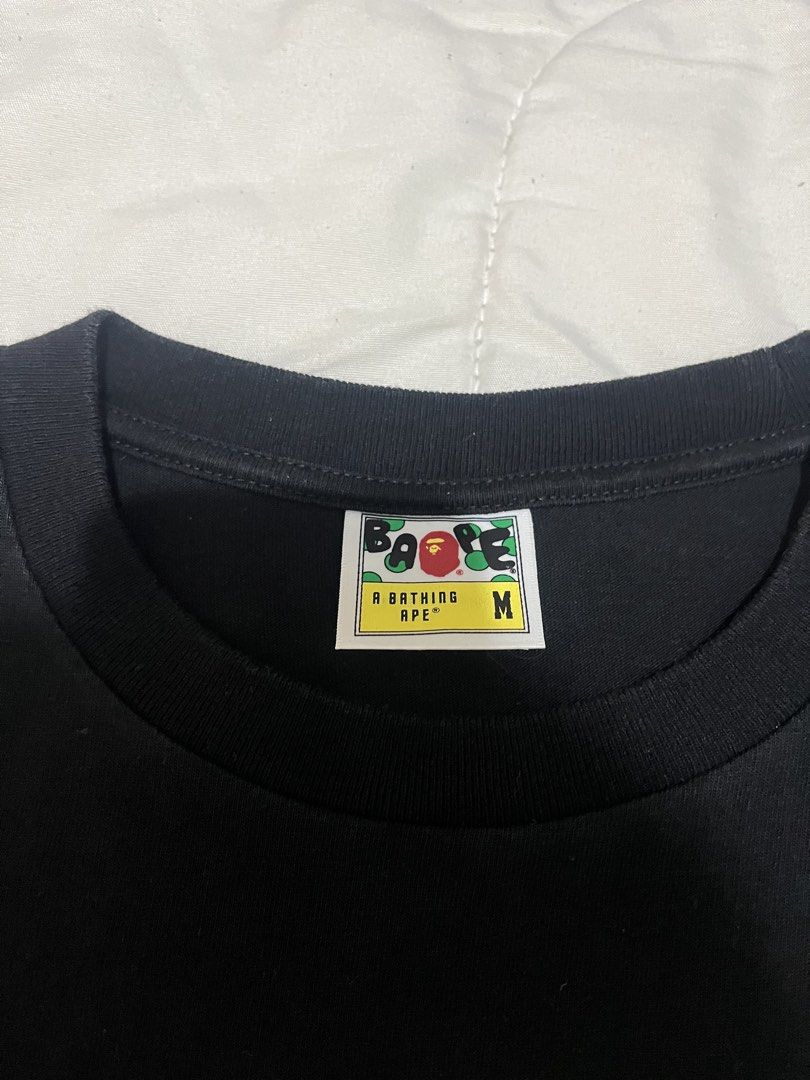 BAPE Green Camo Logo (Category: Tshirts & Polo Shirts ) located in Manila. Submitted by westbridge007 (Listing ID 1471070792, Image 3). Description: BAPE Green Camo Logo T-Shirt – Black Price: ₱3,000 Size: Medium (M, tag shown) Condition: Pre-owned / very good condition Black BAPE graphic tee featuring the iconic green camouflage ape head and A BATHING APE lettering. * Classic streetwear design * Black color with green graphic * Short sleeves * S