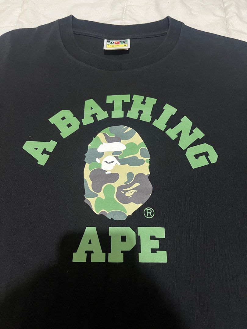 BAPE Green Camo Logo (Category: Tshirts & Polo Shirts ) located in Manila. Submitted by westbridge007 (Listing ID 1471070792, Image 2). Description: BAPE Green Camo Logo T-Shirt – Black Price: ₱3,000 Size: Medium (M, tag shown) Condition: Pre-owned / very good condition Black BAPE graphic tee featuring the iconic green camouflage ape head and A BATHING APE lettering. * Classic streetwear design * Black color with green graphic * Short sleeves * S