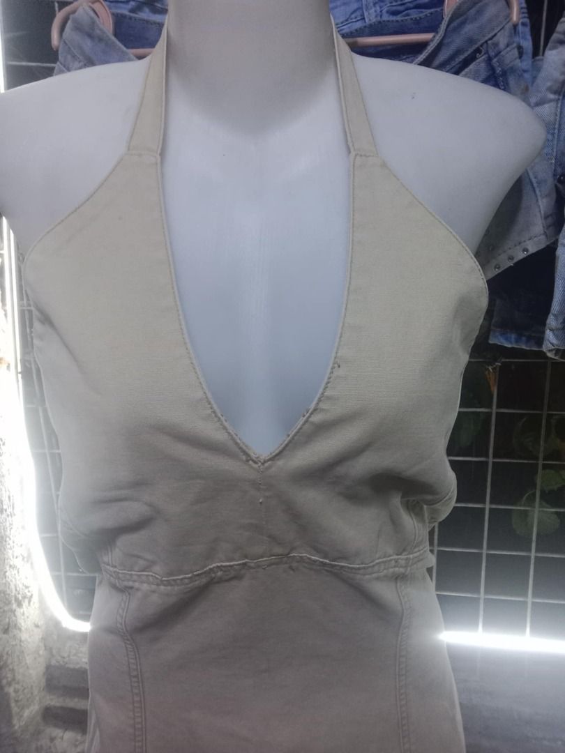 Beige halter neck mini dress (Category: Dresses) located in Quezon City. Submitted by honeyonline.ph (Listing ID 1471053587, Image 2). Description: - Color: Neutral beige - Style: Halter neck, deep V-neckline, backless with neck ties - Silhouette: Structured fit-and-flare with front panel stitching - Length: Above the knee - Fabric: Lightweight and breathable for warm weather - Versatility: Easy to pair with sandals or boots for casual outings.