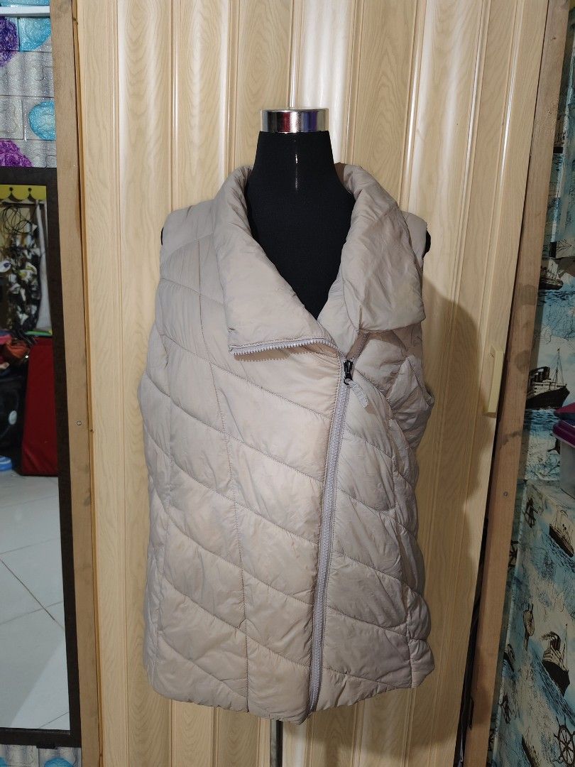 Beige Quilted Puffer Vest Asymmetric Zip (Category: Sleeveless) located in Manila. Submitted by duffy-080 (Listing ID 1470989228, Image 2). Description: - Color: Neutral beige / cream - Design: Quilted diagonal stitching with trendy asymmetric zipper - Features: Warm high collar and two functional side pockets - Style: Sleeveless, ideal for layering over long sleeves - Condition: Brand new / excellent (ready to ship!).