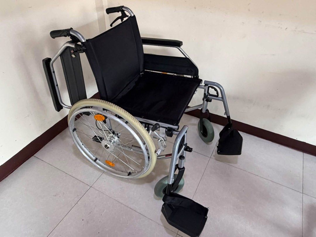 Bischoff & Bischoff Folding Wheelchair Black Silver (Category: Wheelchairs) located in Manila. Submitted by calmdolphin.87b0e4 (Listing ID 1470957146, Image 1). Description: - Brand: Bischoff & Bischoff - Color: Silver frame with black fabric upholstery - Mobility: Large rear wheels with handrims and orange reflectors + smooth front caster wheels - Comfort & Safety: Adjustable footrests with heel straps and push handles for caregivers - Convenien