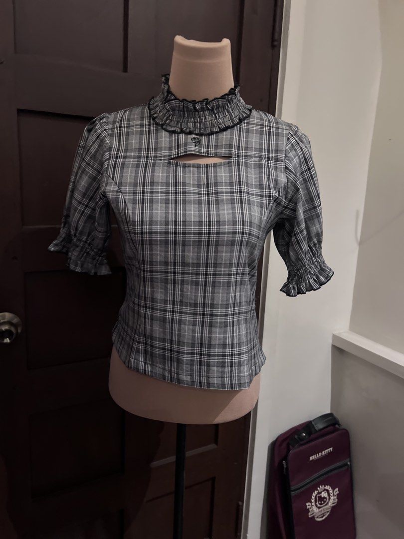 Black and white plaid top with ruffled collar (Category: Blouses) located in Manila. Submitted by nonsensically (Listing ID 1471059329, Image 1). Description: - Color & Pattern: Classic black and white tartan plaid - Style: Fitted silhouette, waist-length - Details: High ruffled collar, neckline cutout, short sleeves with shirred cuffs - Versatility: Perfect to pair with skirts or high-waisted pants - Material: Soft and comfortable fabric.