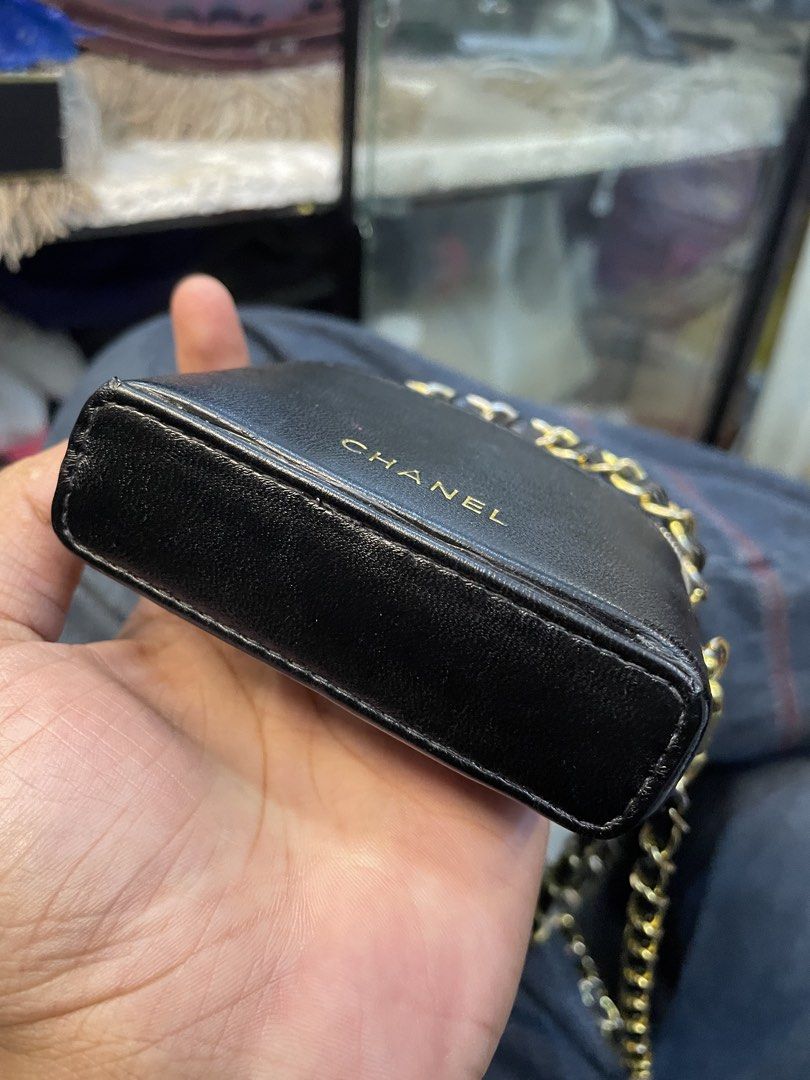 Black Chanel Mini Vanity Crossbody Bag (Category: Luxury Bags & Wallets) located in Cainta. Submitted by riszizlux (Listing ID 1471036376, Image 3). Description: - Color & Material: Black faux leather with elegant gold-tone hardware - Branding: Chanel stamped neatly in gold lettering on the front - Strap: Intertwined leather and chain strap attached via lobster clasps - Closure: Zip-around top opening with a cute zipper pull charm - Design: Compa
