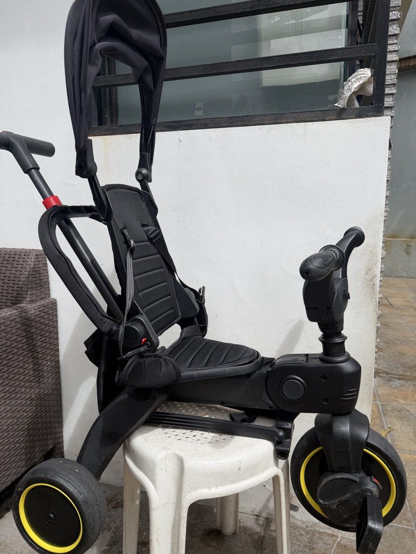 Black Foldable Kids Stroller Tricycle with Canopy and Push Handle (Category: Strollers) located in Taytay. Submitted by kmnlng (Listing ID 1470953032, Image 2). Description: - Convertible toddler trike with parent push handle and black sun canopy - Padded black seat equipped with secure safety harness straps - Convenient front handlebar cup holder attachment - Folds down compactly for easy storage and travel - Stylish wheels with yellow accents.