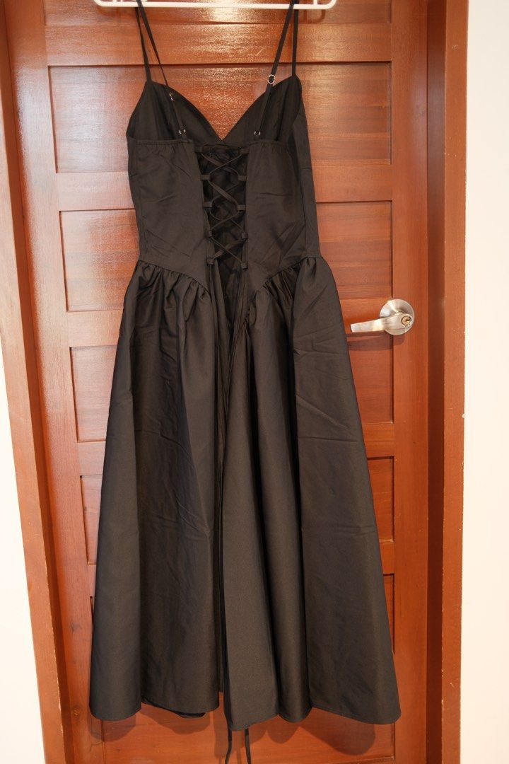Black Spaghetti Strap Midi Dress with Lace-Up Back (Category: Dresses) located in Makati City. Submitted by nomoreclutterph (Listing ID 1471048700, Image 2). Description: - Color: Classic Black - Style: Midi dress with thin spaghetti straps, fitted bodice, and flared skirt - Details: Adjustable criss-cross ribbon lacing at the back with a back zipper closure - Material: Smooth, structured fabric - Versatility: Perfect for dinner dates, parties, o