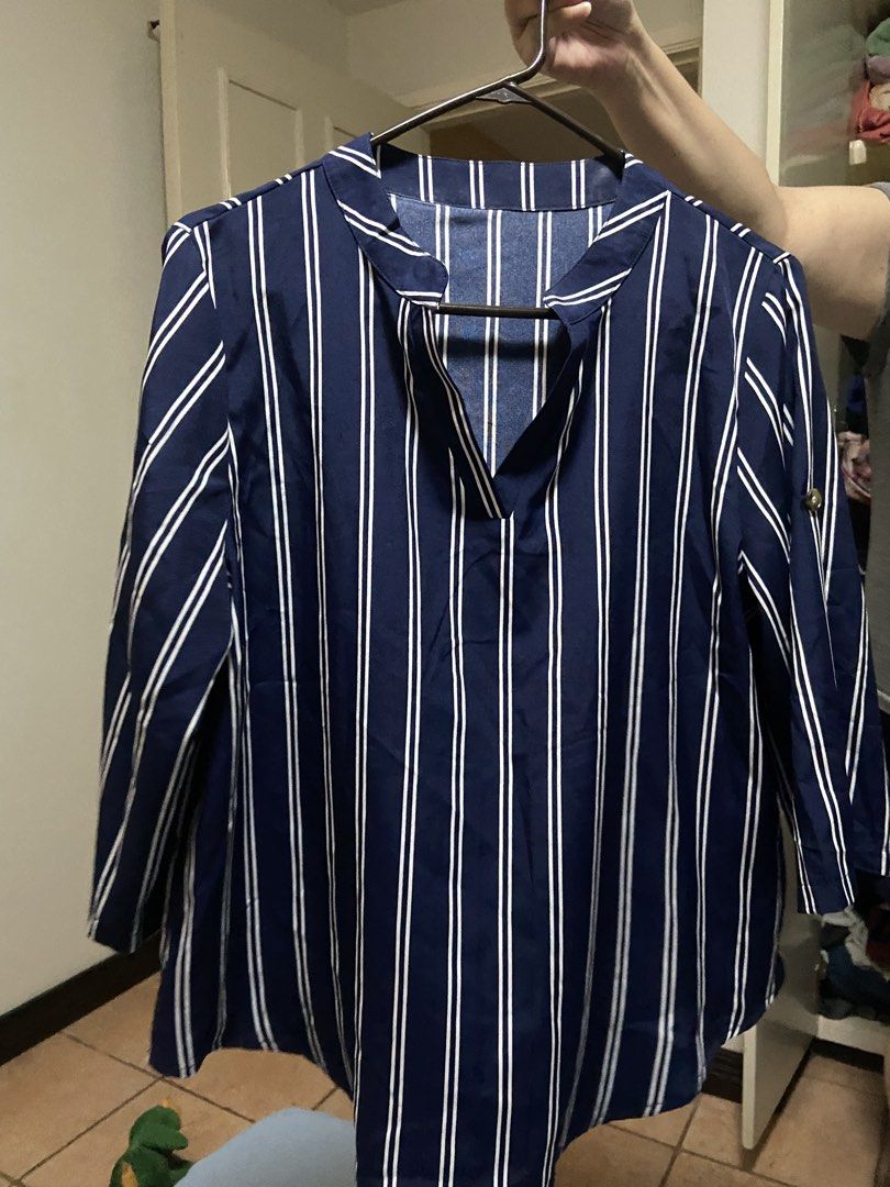 Blue and White Striped V-Neck Blouse (Category: Blouses) located in Manila. Submitted by gigstlauron (Listing ID 1471092337, Image 1). Description: - Color & Pattern: Navy blue with vertical white stripes - Style: V-neckline with folded collar, long sleeves with button tabs - Fit: Relaxed and lightweight, easy to pair with jeans or slacks - Occasion: Perfect for work or casual outings - Condition: Clean, well-kept, and ready to wear.