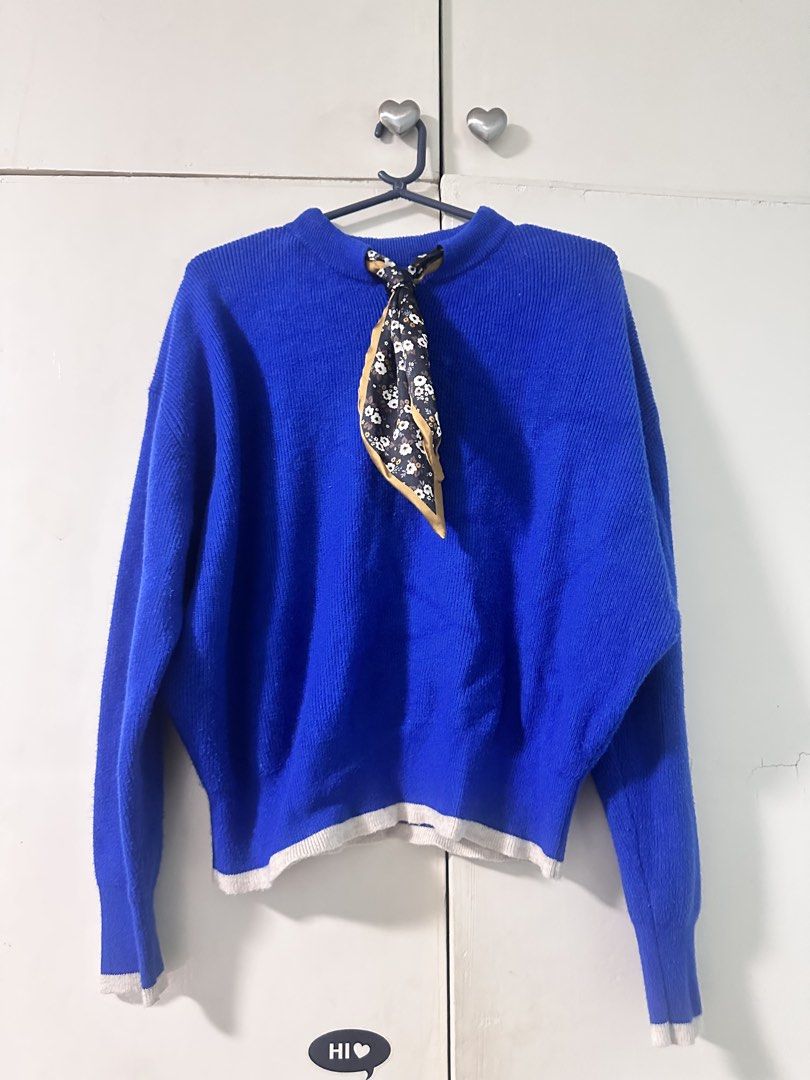 Blue Knit Sweater With Scarf (Pullover) (Category: Coats, Jackets and Outerwear) located in Quezon City. Submitted by bentabelles (Listing ID 1471029613, Image 1). Description: - Color: Bright blue with black and white floral scarf - Material: Cozy knit fabric, perfect for colder days - Fit: Relaxed and slouchy - Details: Long sleeves, ribbed white trim on cuffs and hem, attached patterned mini scarf - Styling: Pairs easily with jeans or skirts.