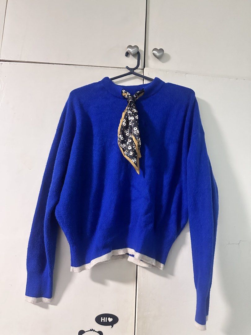 Blue Knit Sweater With Scarf (Pullover) (Category: Coats, Jackets and Outerwear) located in Quezon City. Submitted by bentabelles (Listing ID 1471029613, Image 2). Description: - Color: Bright blue with black and white floral scarf - Material: Cozy knit fabric, perfect for colder days - Fit: Relaxed and slouchy - Details: Long sleeves, ribbed white trim on cuffs and hem, attached patterned mini scarf - Styling: Pairs easily with jeans or skirts.