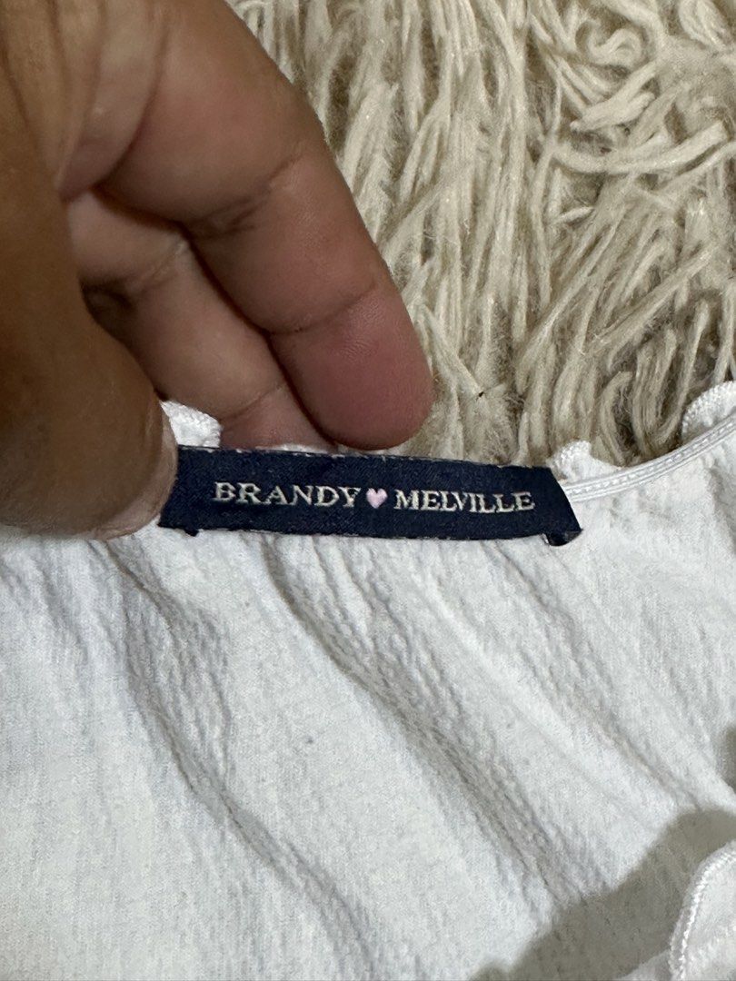 Brandy Melville White Ruffle Tie-Front Tank Top (Category: Sleeveless) located in General Santos City (Dadiangas). Submitted by darylvoid (Listing ID 1470993316, Image 2). Description: - Brand: Brandy Melville - Color: White - Style Code: MH506A-Z368S - Material: 55% cotton, 42% polyamide, 3% spandex - Features: Sweetheart neckline, front tie detail, and ruffle trim - Fabric: Lightweight with a crinkled texture - Condition: Great basic piece for 