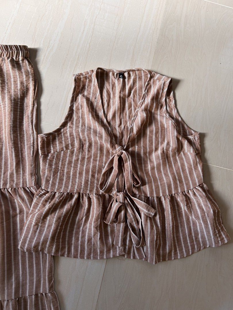 Brown Coords Pants Set- XL (Category: Sets or Coordinates) located in Caloocan City. Submitted by declutterieee (Listing ID 1471028162, Image 1). Description: - Color/Pattern: Brown and white vertical stripes - Set includes: Sleeveless top and matching pants - Top details: Double front ties and a cute ruffled hem - Pants details: Comfy elastic waistband and stylish tiered ruffled legs - Fabric: Lightweight and breathable material - Condition: Bra