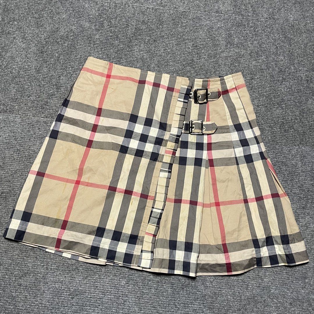 Burberry beige Nova Check patterned pleated mini wrap skirt (Category: Luxury Apparel) located in Iloilo. Submitted by 3ift2heav3n (Listing ID 1471075967, Image 3). Description: Burberry beige Nova Check patterned pleated mini wrap skirt featuring side leather and metal buckle straps. Excellent condition Waistline 26-28.