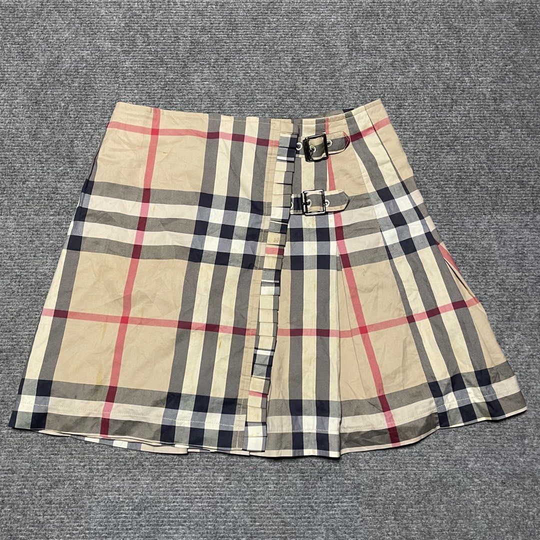 Burberry beige Nova Check patterned pleated mini wrap skirt (Category: Luxury Apparel) located in Iloilo. Submitted by 3ift2heav3n (Listing ID 1471075967, Image 2). Description: Burberry beige Nova Check patterned pleated mini wrap skirt featuring side leather and metal buckle straps. Excellent condition Waistline 26-28.
