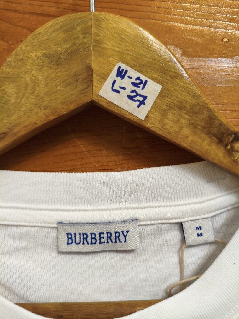 Burberry Brand Shirt🔥 (Category: Luxury Apparel) located in Manila. Submitted by thrift_cy01 (Listing ID 1471082152, Image 3). Description: Available sizes M and L only. M - W21 L27 L - W22 L28 - Brand: Burberry - Color: Crisp White with Blue Equestrian Knight Design - Material: 100% Premium Cotton (Made in Portugal) - Fit: Classic fit, short sleeves, crew neck, straight hem - Condition: Brand new with retail tags attached.