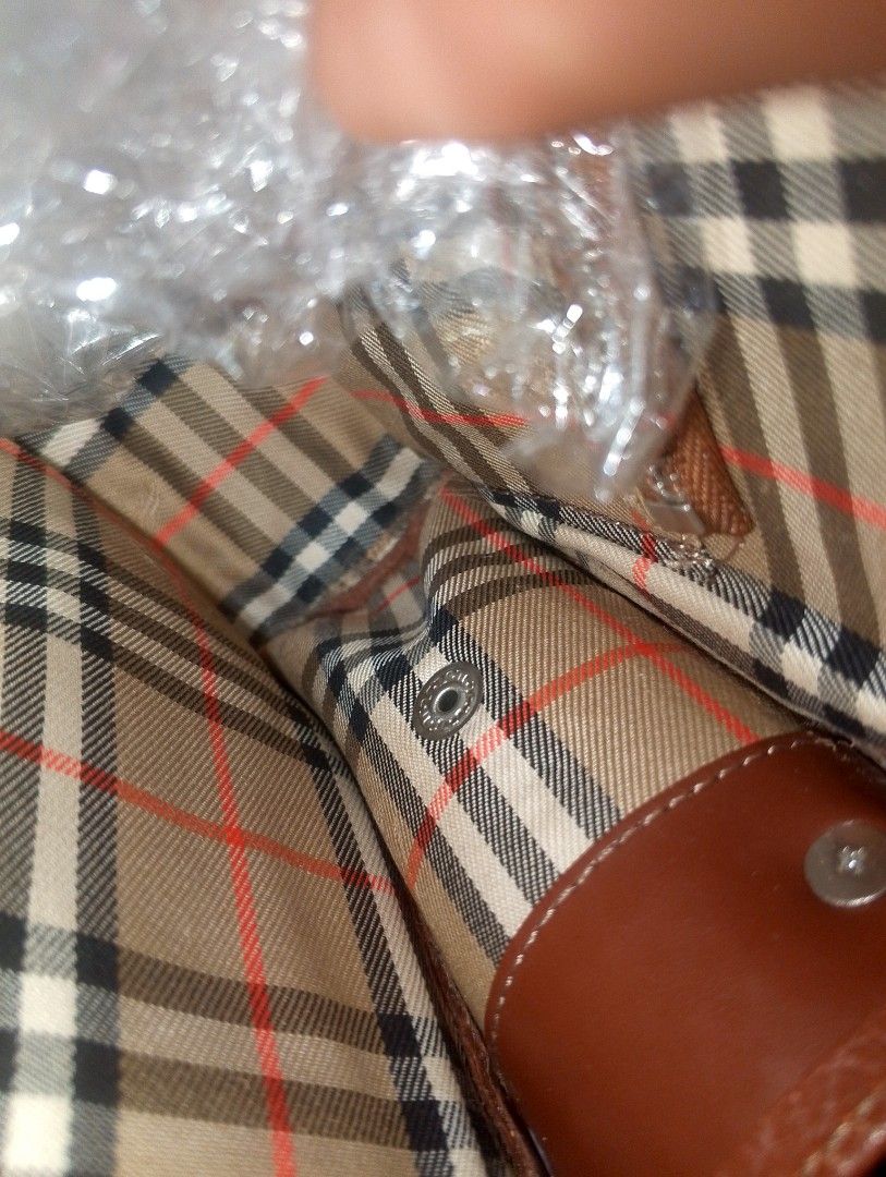 Burberry Brown Leather Handbag (Category: Luxury Bags & Wallets) located in Caloocan City. Submitted by ndkph (Listing ID 1470975391, Image 3). Description: - Authentic brown leather Burberry handbag with grainy texture - Features a stylish structured center stripe and embossed equestrian knight logo - Secure zip-top closure with a handy front slip pocket - Strap attached at the base for a unique look - Spacious interior easily holds your phone, 