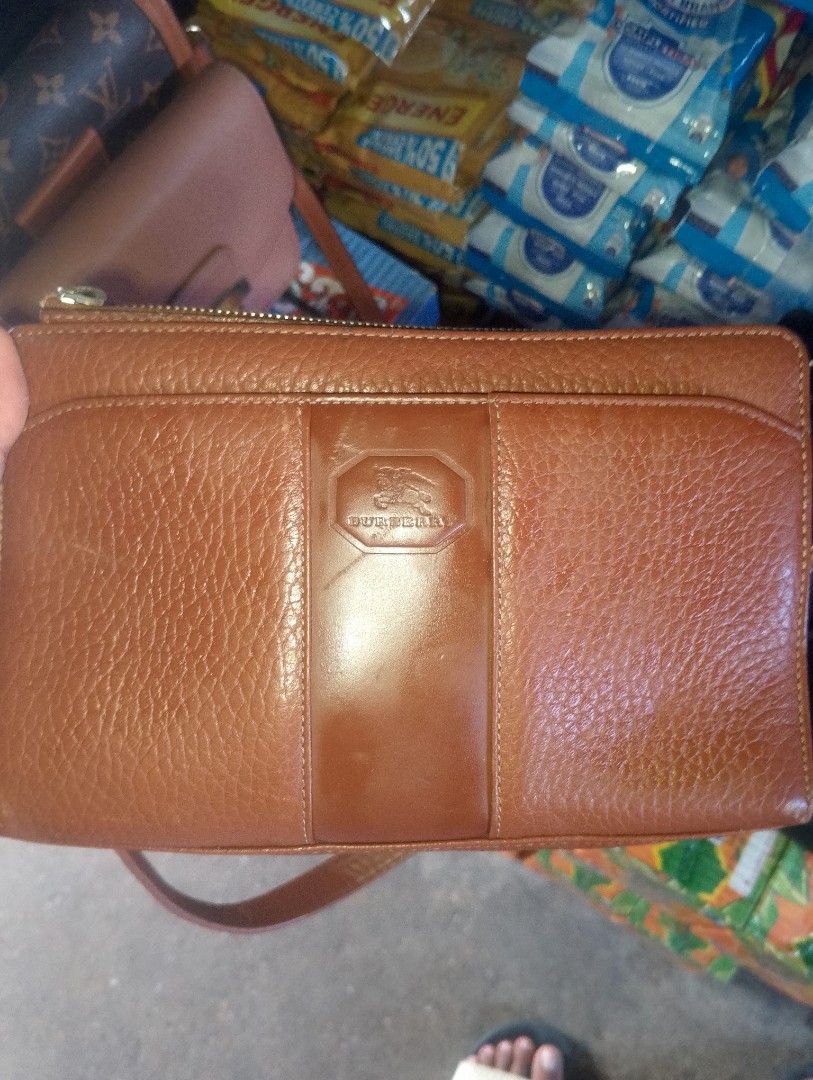 Burberry Brown Leather Handbag (Category: Luxury Bags & Wallets) located in Caloocan City. Submitted by ndkph (Listing ID 1470975391, Image 1). Description: - Authentic brown leather Burberry handbag with grainy texture - Features a stylish structured center stripe and embossed equestrian knight logo - Secure zip-top closure with a handy front slip pocket - Strap attached at the base for a unique look - Spacious interior easily holds your phone, 