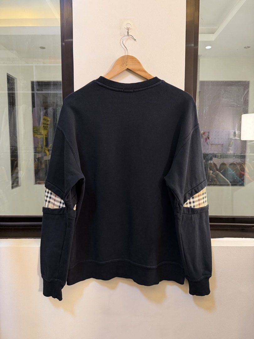 Burberry Crewneck Sweatshirt (Category: Coats, Jackets and Outerwear) located in Paranaque City. Submitted by preluxeshop_ph (Listing ID 1471015574, Image 3). Description: Brand: Burberry London, England •Style: Crewneck Sweatshirt / Pullover •Color: Black •Design Features: Embroidered TB monogram logo on the left chest pocket, distinctive vintage check plaid inserts along both sleeves, crew neckline, and ribbed collar, cuffs, and hem •Material C