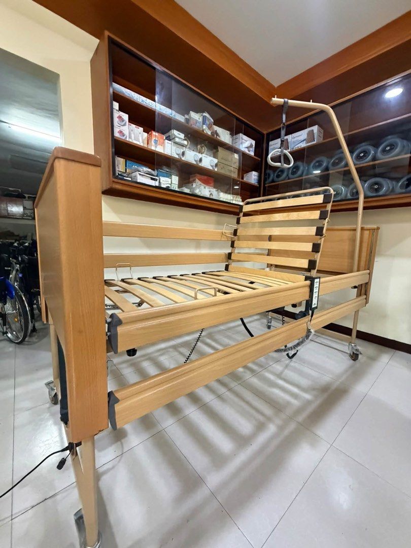 Burmeier Electric Nursing Bed with Overhead Lifting Pole (Category: Medical Supplies & Tools) located in Manila. Submitted by calmdolphin.87b0e4 (Listing ID 1470955713, Image 3). Description: - Brand: Burmeier Electric Care Bed - Condition: Clean and fully functional - Adjustments: Powered by adjustable actuators with easy-to-use hand controller - Safety & Support: Includes wooden side rails, slatted base, and patient-lifting pole with overhead g