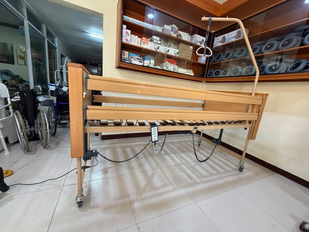 Burmeier Electric Nursing Bed with Overhead Lifting Pole (Category: Medical Supplies & Tools) located in Manila. Submitted by calmdolphin.87b0e4 (Listing ID 1470955713, Image 1). Description: - Brand: Burmeier Electric Care Bed - Condition: Clean and fully functional - Adjustments: Powered by adjustable actuators with easy-to-use hand controller - Safety & Support: Includes wooden side rails, slatted base, and patient-lifting pole with overhead g