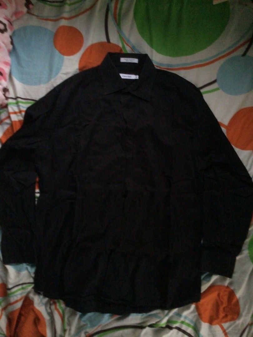 Calvin Klein Black Long Sleeve (Category: Longsleeves) located in General Trias. Submitted by dunht (Listing ID 1471081680, Image 1). Description: - Brand: Calvin Klein - Color: Solid Black - Size: 16, Sleeve Length 32-33 - Material: 97% Cotton, 3% Lastol XLA - Design: Standard collar with front button closure - Origin: Made in Thailand - Condition/Style: Clean lines, classic formal wear piece.