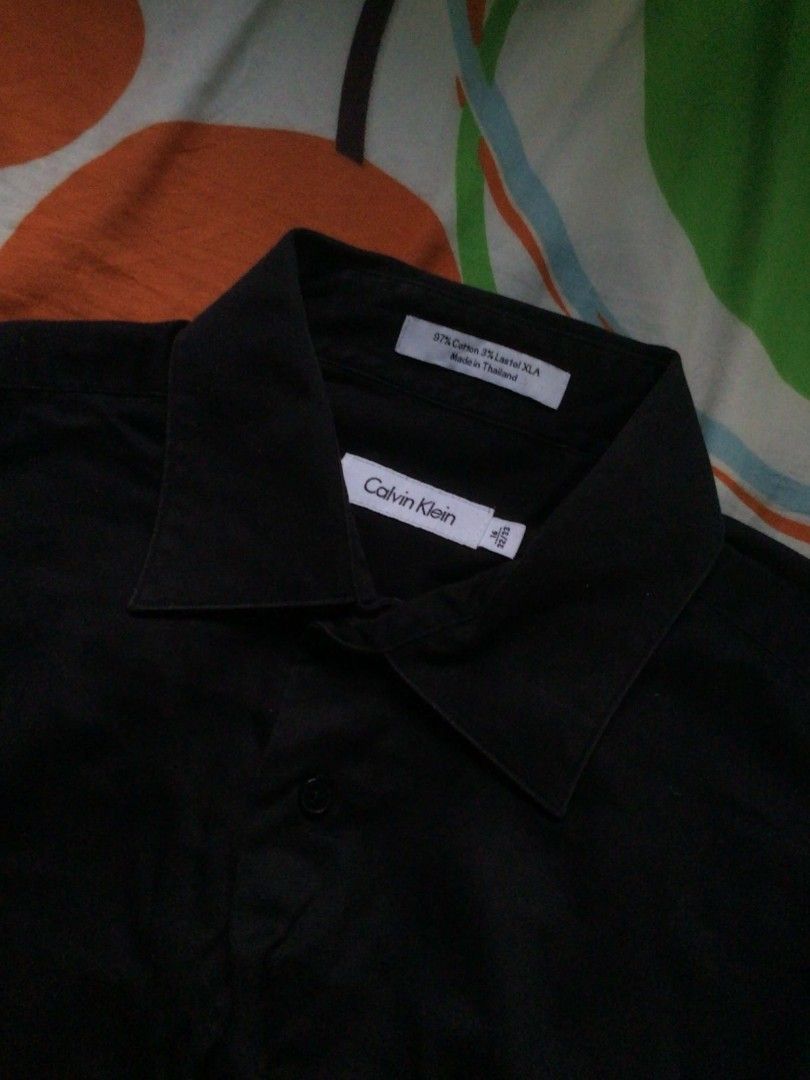 Calvin Klein Black Long Sleeve (Category: Longsleeves) located in General Trias. Submitted by dunht (Listing ID 1471081680, Image 2). Description: - Brand: Calvin Klein - Color: Solid Black - Size: 16, Sleeve Length 32-33 - Material: 97% Cotton, 3% Lastol XLA - Design: Standard collar with front button closure - Origin: Made in Thailand - Condition/Style: Clean lines, classic formal wear piece.