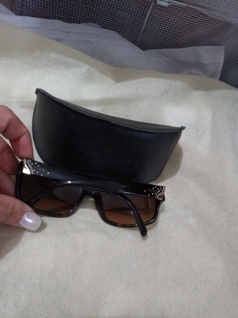 Calvin Klein Sunglasses with Case (Category: Sunglasses & Eyewear) located in Quezon. Submitted by ja8720 (Listing ID 1471052788, Image 2). Description: - Brand: Calvin Klein (Made in Italy) - Lenses: Brown gradient - Frames: Dark with subtle rhinestone crystal accents and Calvin Klein logo near the temples - Includes: Original black branded hard case - Condition: Excellent, well-maintained - Perfect for adding a touch of everyday luxury to your 