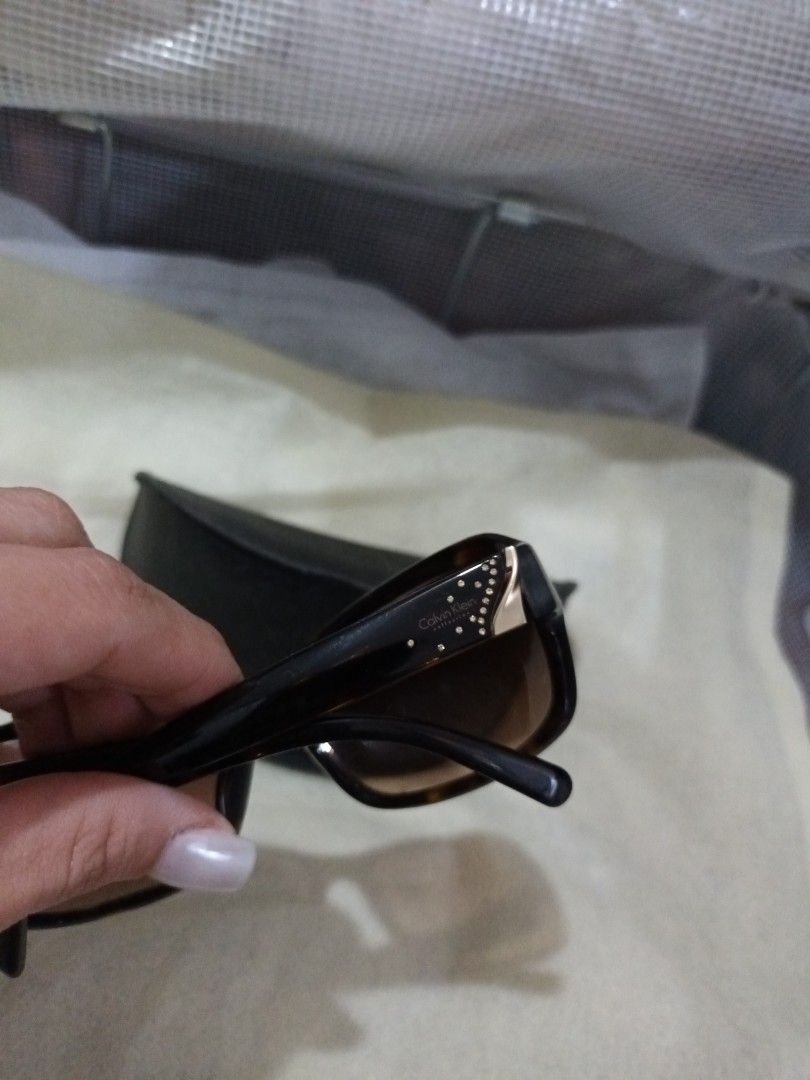 Calvin Klein Sunglasses with Case (Category: Sunglasses & Eyewear) located in Quezon. Submitted by ja8720 (Listing ID 1471052788, Image 3). Description: - Brand: Calvin Klein (Made in Italy) - Lenses: Brown gradient - Frames: Dark with subtle rhinestone crystal accents and Calvin Klein logo near the temples - Includes: Original black branded hard case - Condition: Excellent, well-maintained - Perfect for adding a touch of everyday luxury to your 