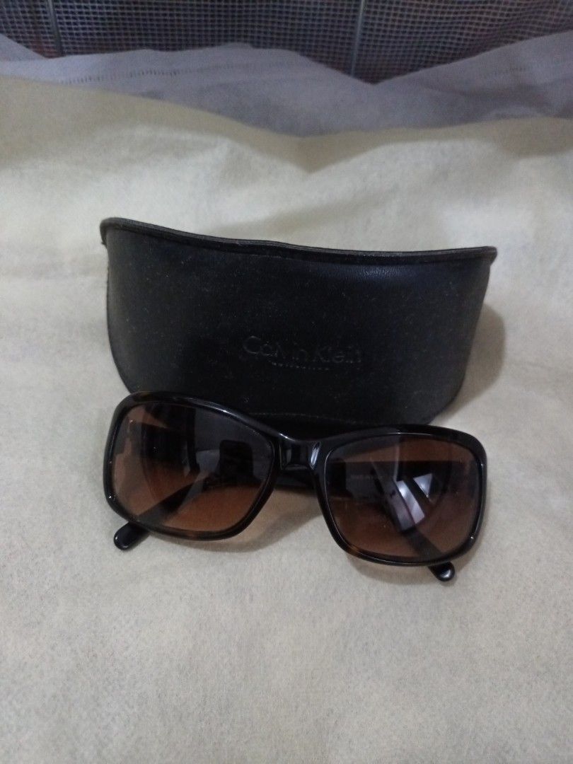 Calvin Klein Sunglasses with Case (Category: Sunglasses & Eyewear) located in Quezon. Submitted by ja8720 (Listing ID 1471052788, Image 1). Description: - Brand: Calvin Klein (Made in Italy) - Lenses: Brown gradient - Frames: Dark with subtle rhinestone crystal accents and Calvin Klein logo near the temples - Includes: Original black branded hard case - Condition: Excellent, well-maintained - Perfect for adding a touch of everyday luxury to your 