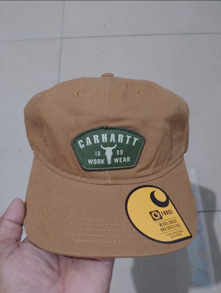 Carhartt Force Work Wear Brown Cap (Category: Caps & Hats) located in Manila. Submitted by thriftyboyzzz (Listing ID 1470998156, Image 1). Description: - Brand: Carhartt - Color: Brown with unique green bull skull patch (1889 work wear branding) - Technology: Force sweatband inside for quick-drying sweat-wicking comfort - Material: 100% Cotton - Fit: Adjustable strap back with Carhartt logo label (OSFA - One Size Fits All) - Condition: Brand new 