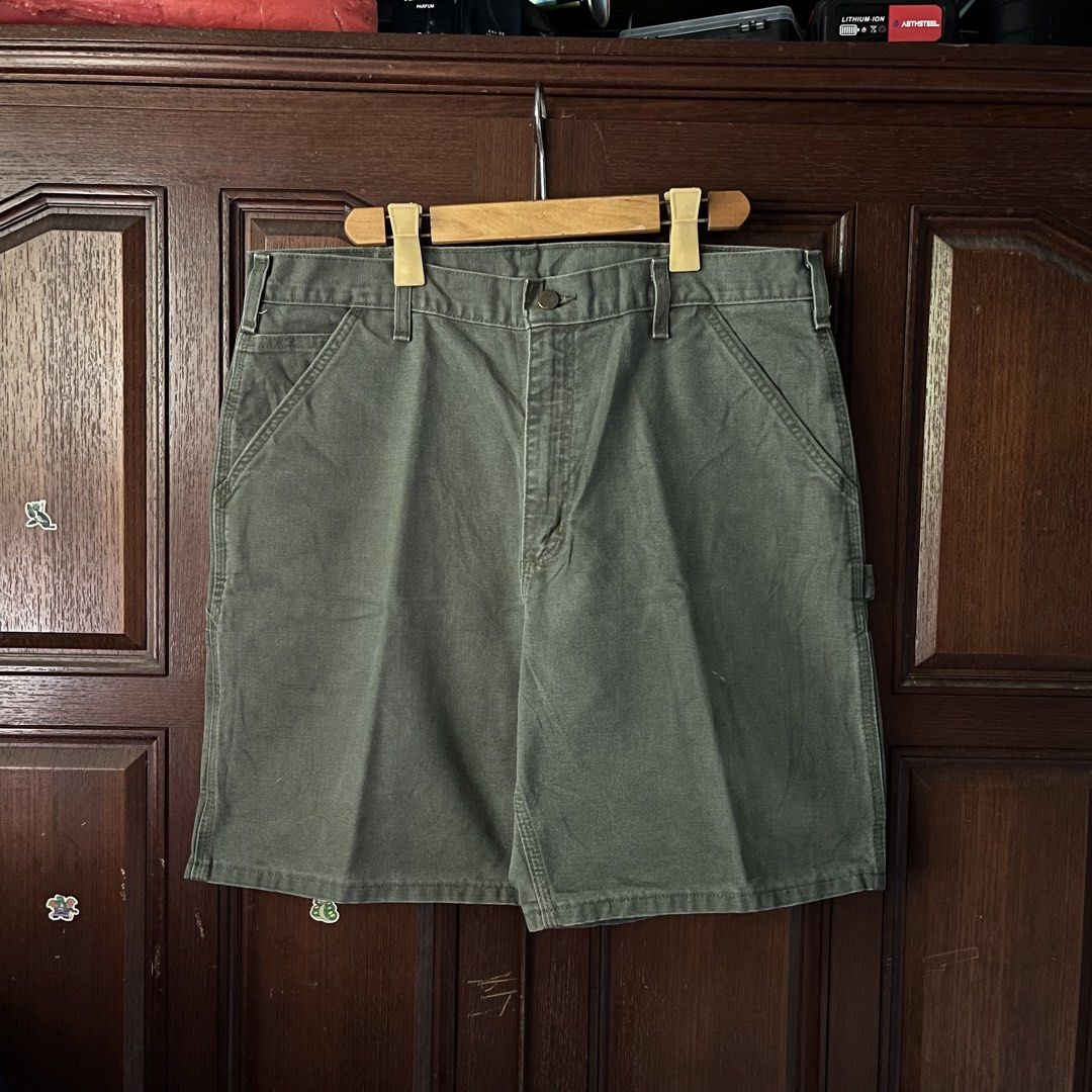 Carhartt moss green carpenter shorts (Category: Shorts) located in Manila. Submitted by thriftyyyyy. (Listing ID 1470989975, Image 2). Description: - Brand/Item: Carhartt Canvas Utility Shorts - Color: Olive Green - Features: Double front pockets, hammer loop, and tool pockets - Details: Classic leather logo patch on the right back pocket with button fly closure - Condition: Rugged workwear style with some minor surface marks and faint spotting f