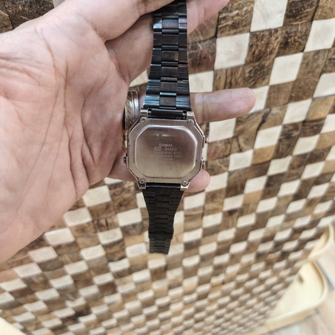 Casio B650W Digital Watch (Category: Men's Watches) located in Manila. Submitted by narju1234 (Listing ID 1470960909, Image 3). Description: Casio digital watch with a silver-tone square case and black metal band. Features illuminator backlight, alarm, and water resistance up to 5 bar. Digital display shows day, date, and time. Standard push buttons on the sides for mode adjustments. Case back shows model B650W and stainless steel back details. W