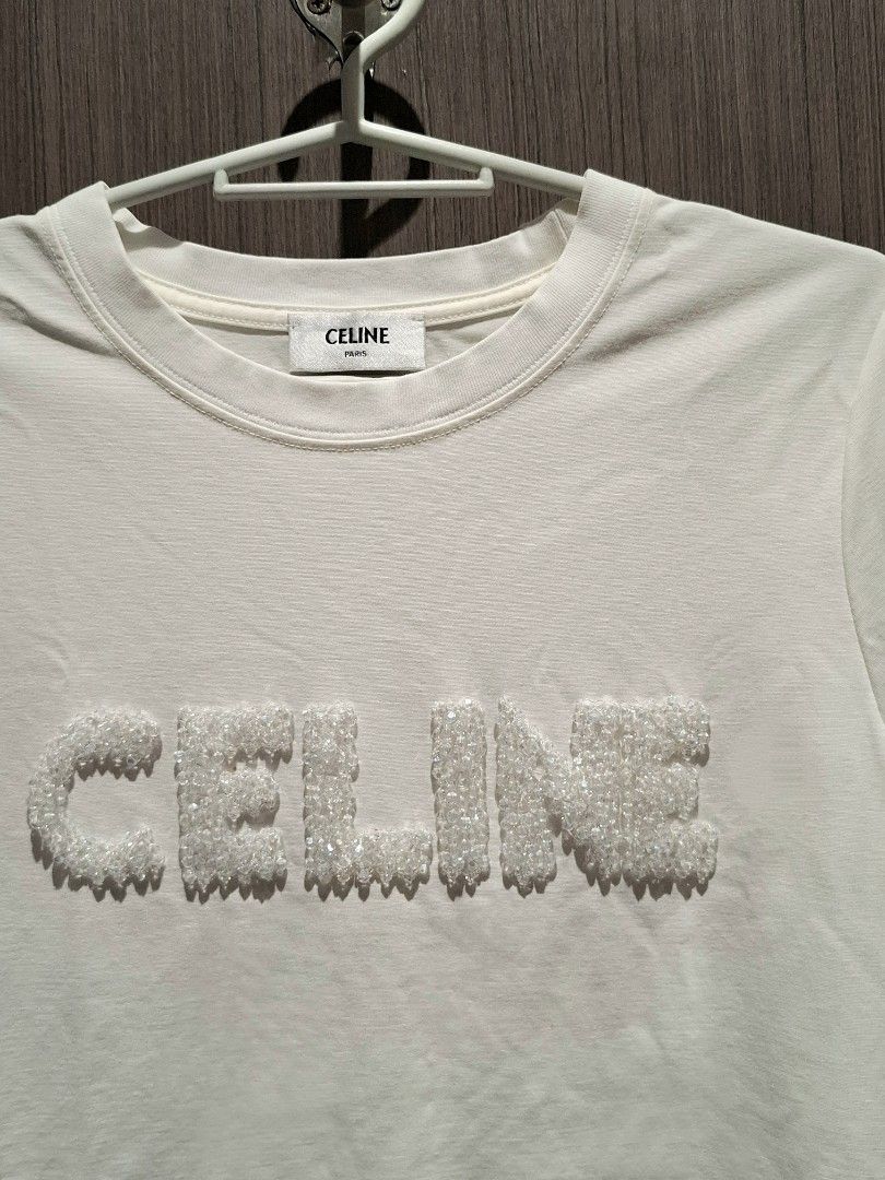Celine SS21 Crystal Logo Shirt (Category: Shirts) located in Pasig City. Submitted by coveted.mnl (Listing ID 1471015417, Image 2). Description: In Pristine Condition📌 Best fit to: Medium Width : 17 Length : 24 (MEASURED BY INCHES) 9.5/10 overall condition No issues or flaws in fabric Retailed for $1,350 (P86,400) • P600 Slightly negotiable • Pasig City meet up • Open for COD Via Lalamove or Grab • J&T courier Message us for more info🤍 (measure