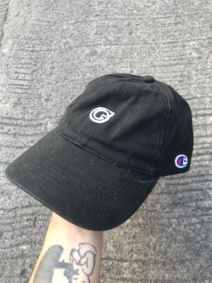 Champion Black Baseball Cap with Embroidered Logo (Category: Caps & Hats) located in Imus. Submitted by yoboi.04 (Listing ID 1471005124, Image 1). Description: - Brand: Champion - Color: Classic Black - Design: Six-panel construction with curved brim - Branding: Embroidered logo on the front, small patch on the side, and branded interior tag - Fit: Adjustable strapback with metal buckle - Condition: Shows minor dust and light wear on the fabric s