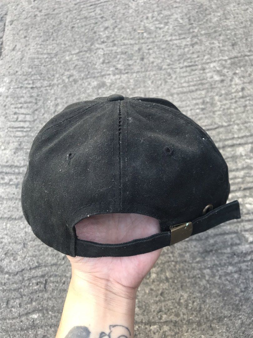 Champion Black Baseball Cap with Embroidered Logo (Category: Caps & Hats) located in Imus. Submitted by yoboi.04 (Listing ID 1471005124, Image 2). Description: - Brand: Champion - Color: Classic Black - Design: Six-panel construction with curved brim - Branding: Embroidered logo on the front, small patch on the side, and branded interior tag - Fit: Adjustable strapback with metal buckle - Condition: Shows minor dust and light wear on the fabric s