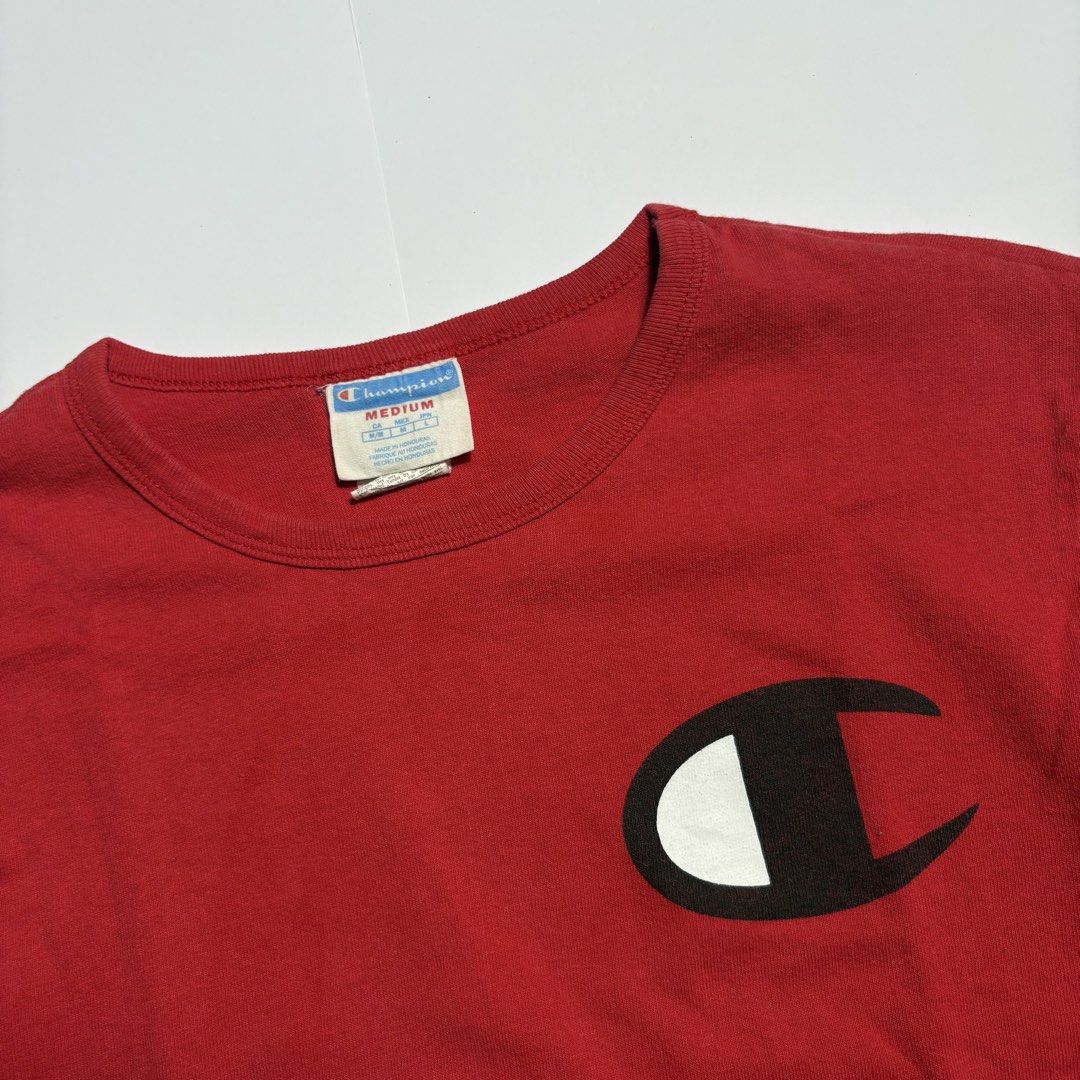 Champion Red Long Sleeve T-Shirt Medium (Category: Tshirts & Polo Shirts ) located in San Fernando. Submitted by lumang_gamit (Listing ID 1471065457, Image 3). Description: - Brand: Champion - Color: Red - Size: Medium (Made in Honduras) - Design: Big C logo on chest, text graphic on right sleeve, and embroidered patch on left cuff - Details: Ribbed collar and cuffs for a comfortable fit - Condition: Excellent, ready to wear.