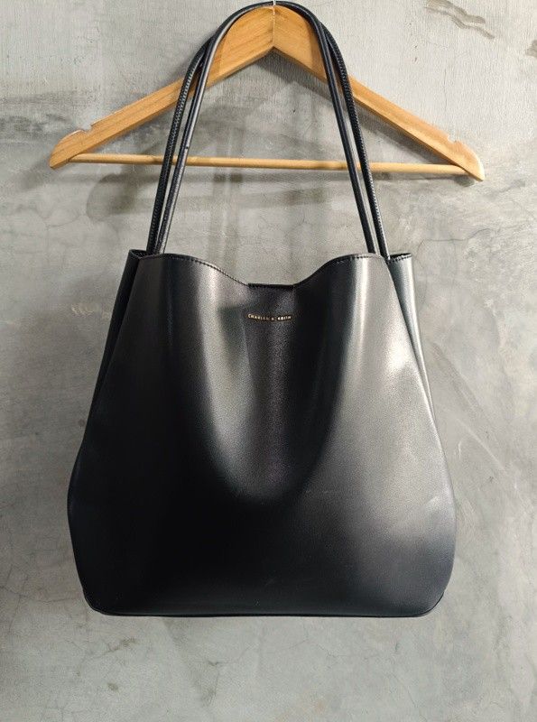 Charles & Keith Leia Black Leather Tote Bag (Category: Tote Bags) located in Bacoor. Submitted by nineties_kid (Listing ID 1471013839, Image 2). Description: •==> Charles & Keith Leia Black Leather Tote Bag Size: Large Bag width/dimension: 13 x 15.5 x 16.5 x 13.5 Bag length: 13 inches Bag space: 4.8 inches Strap length: 12 inches Issues: Scratches as a sign of use. Leather edges breakage. Bottom leather wrinkles. All issues provided in photos. __