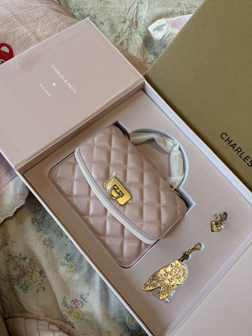 Charles & Keith Quilted Pink Handbag Gift Box Set (Category: Luxury Bags & Wallets) located in Manila. Submitted by xiaoyaoo444 (Listing ID 1471008274, Image 3). Description: - Brand: Charles & Keith - Item: Exclusive Pink Quilted Handbag Gift Box Set - Inclusions: Quilted top-handle bag, gold heart charm, and sparkly wing bag charm - Packaging: Comes in the original pink presentation box with outer sleeve - Condition: Unused with protective wrap