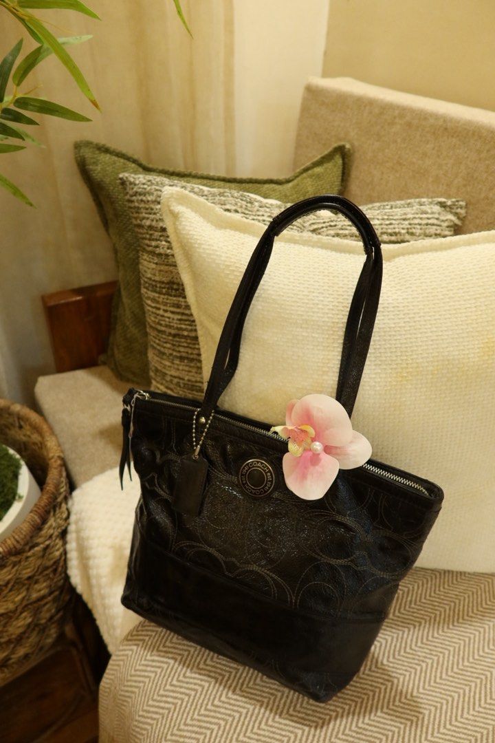 Coach Black Leather Tote Bag (Category: Luxury Bags & Wallets) located in Arayat. Submitted by sunnydienna (Listing ID 1471061946, Image 1). Description: Coach black tote bag in crinkled patent leather with signature C pattern embossing. Double shoulder straps, top zipper closure, fabric lining inside. Coach creed patch stitched on interior pocket. Includes hangtag. issue: slight flaw sa pinaka attachment ng isang handle but all goods, di sya sir