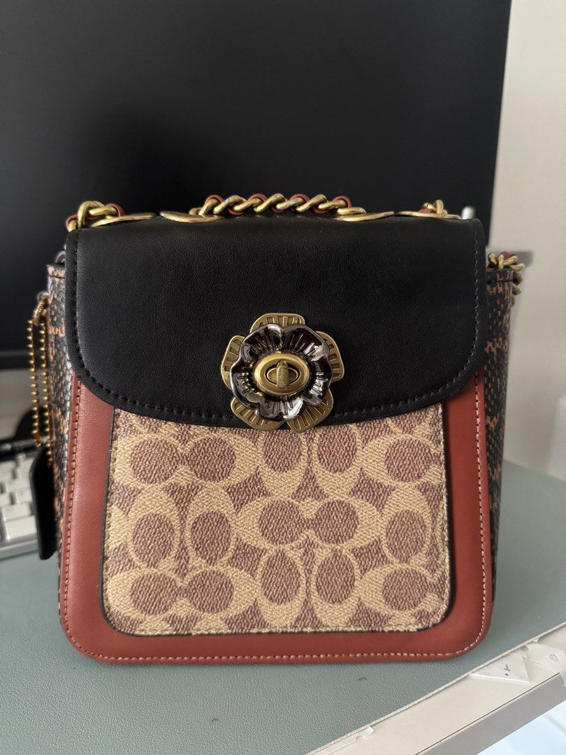 Coach Convertible backpack/Crossbody (Category: Luxury Bags & Wallets) located in Cagayan de Oro. Submitted by dan_kit (Listing ID 1470968931, Image 1). Description: - Brand: Coach Parker - Material: Signature canvas with black leather, red trim, and genuine snakeskin side panels - Hardware: Dark brass with a stylish floral turnlock closure - Strap: Versatile chain and leather strap for multiple ways of wearing - Features: Convenient exterior bac
