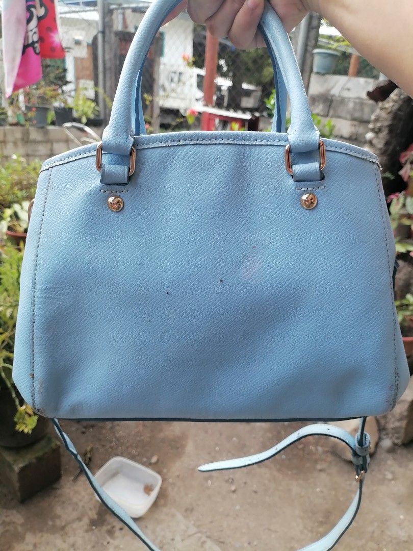 Coach Light Blue Leather Handbag with Crossbody Strap (Category: Luxury Bags & Wallets) located in Digos. Submitted by crodualady82694 (Listing ID 1470972881, Image 2). Description: - Brand: Coach - Color: Light Blue - Material: Genuine Leather - Hardware: Gold-tone - Features: Top handles, detachable crossbody strap, front logo plate - Interior: Zip middle compartment with open side pockets - Condition: Shows some scuffs and marks on the exterio