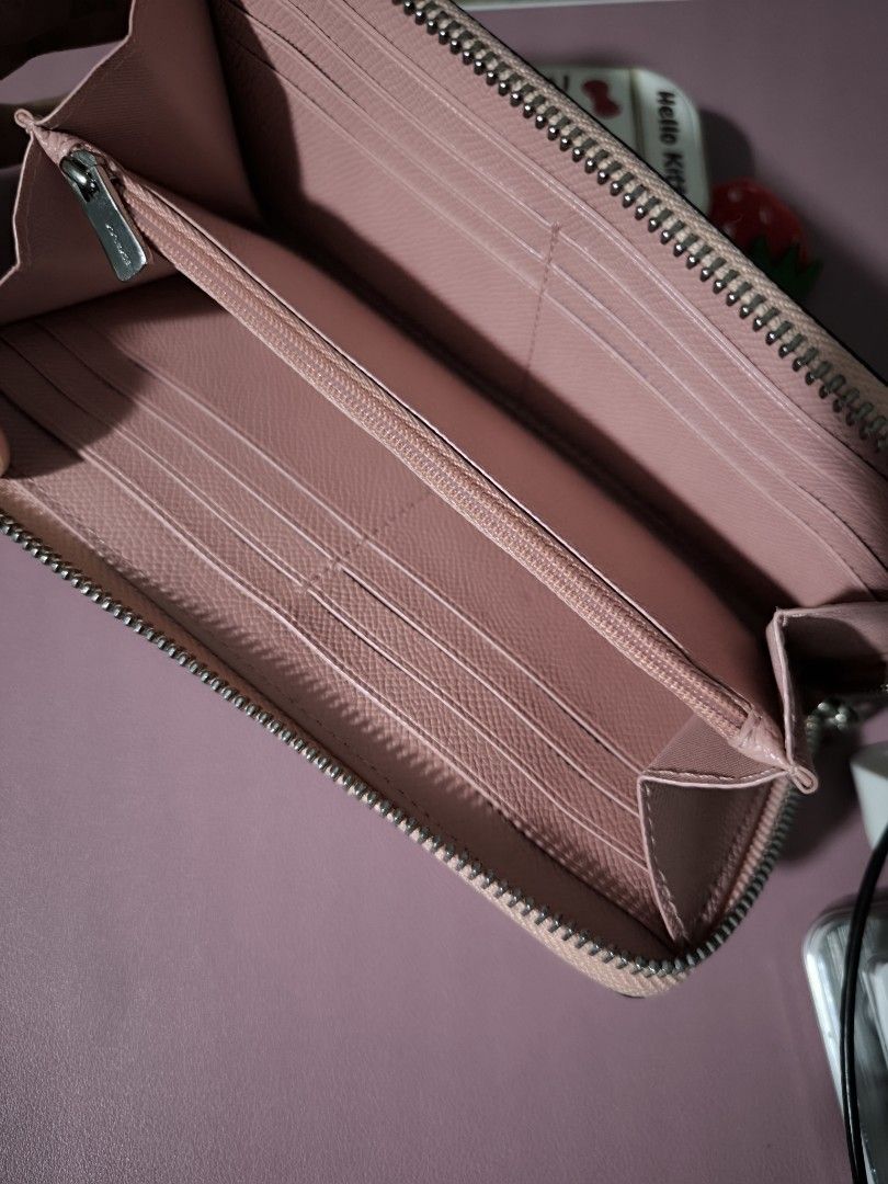 Coach Pink Leather Zip Around Wallet (Category: Wallets & Card holders) located in Taytay. Submitted by misspol (Listing ID 1471086507, Image 2). Description: - Brand: Coach - Material: Soft pink crossgrain leather with silver hardware - Closure: Zip-around - Exterior: Slip pocket with metal Coach logo - Interior: Multiple card slots, full-length compartments, and a zippered coin pocket - Condition: Clean inside and out, excellent and ready-to-us