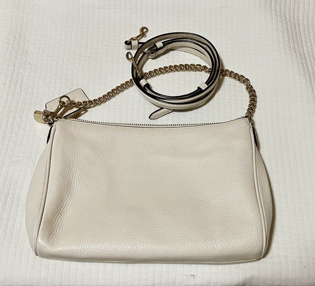 Coach White Leather Shoulder Bag with Gold Chain (Category: Luxury Bags & Wallets) located in Bay. Submitted by ronellie (Listing ID 1471096864, Image 2). Description: - Authentic Coach shoulder bag in classic white pebbled leather - Elegant gold-tone hardware with secure zipper closure - Includes a removable chain strap for a chic look - Comes with a long adjustable leather strap for crossbody wear - Accented with the signature leather hangtag -